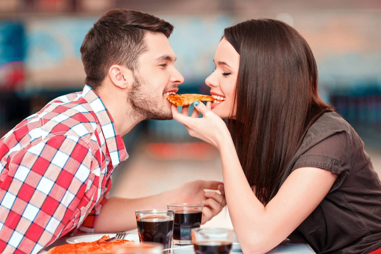 Парень и девушка едят пиццу